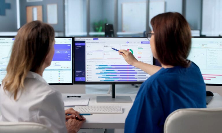 Clinical research professional using a laptop with digital trial dashboards, representing CTMS platforms integrated with EDC and eTMF