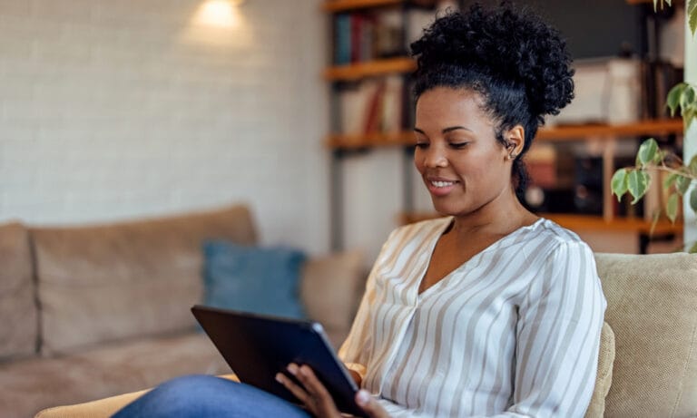 Participant using a tablet at home to complete ePRO or eCOA assessments for a clinical trial.
