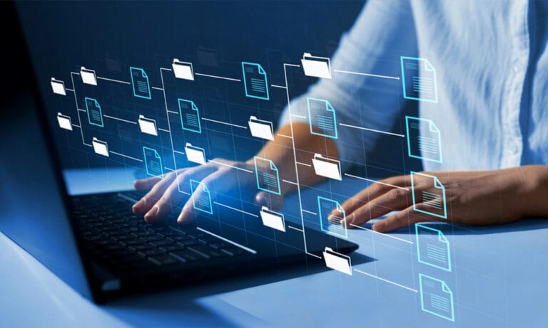 Clinical trial professional using a laptop with digital document folders representing an electronic Trial Master File (eTMF).
